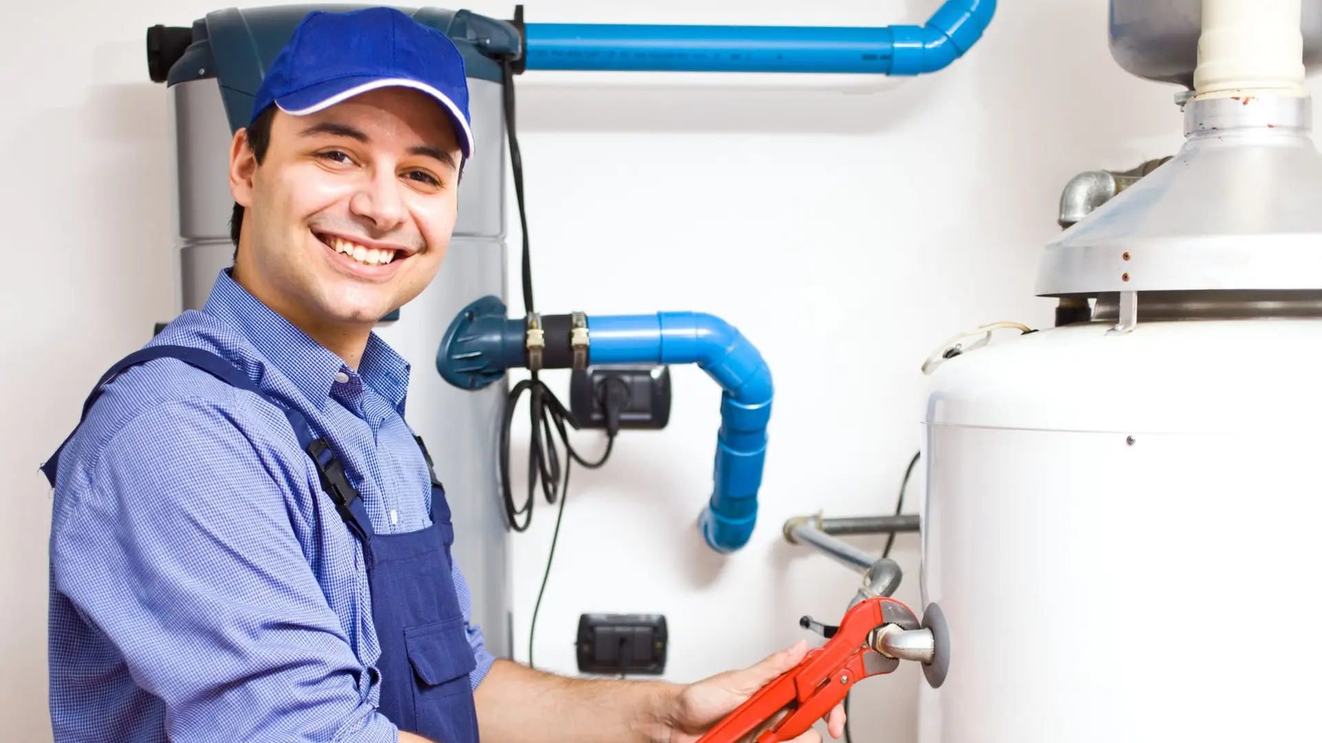 Smiling plumber repairing water heater