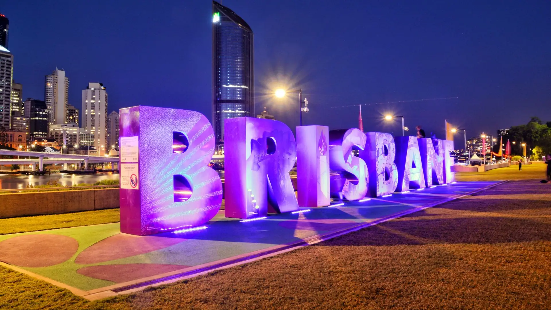 Illuminated Brisbane sign at night.