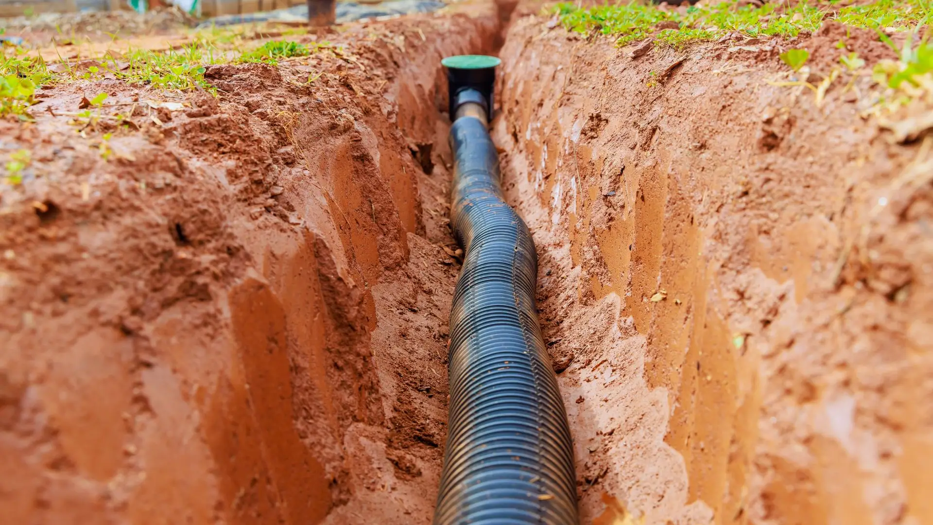 Black drainage pipe in soil trench