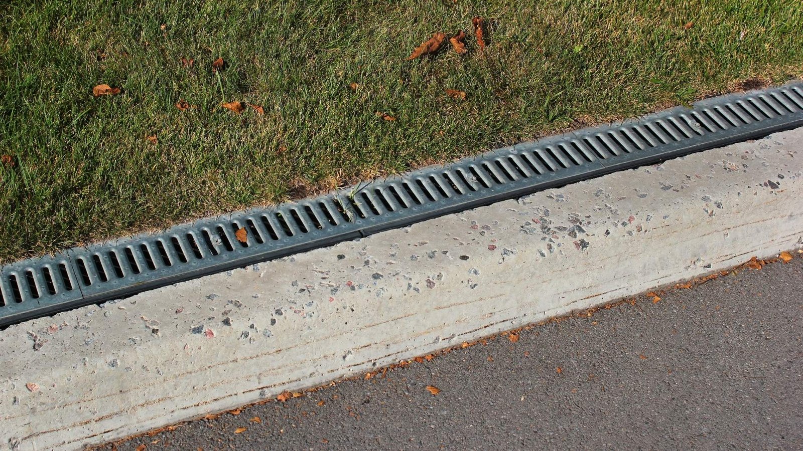 Concrete curb with metal drainage grate
