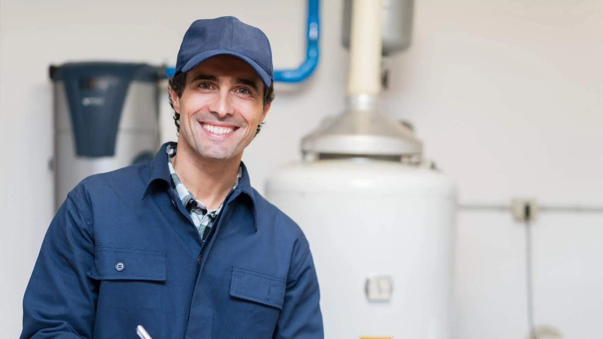 Smiling plumber near water heater