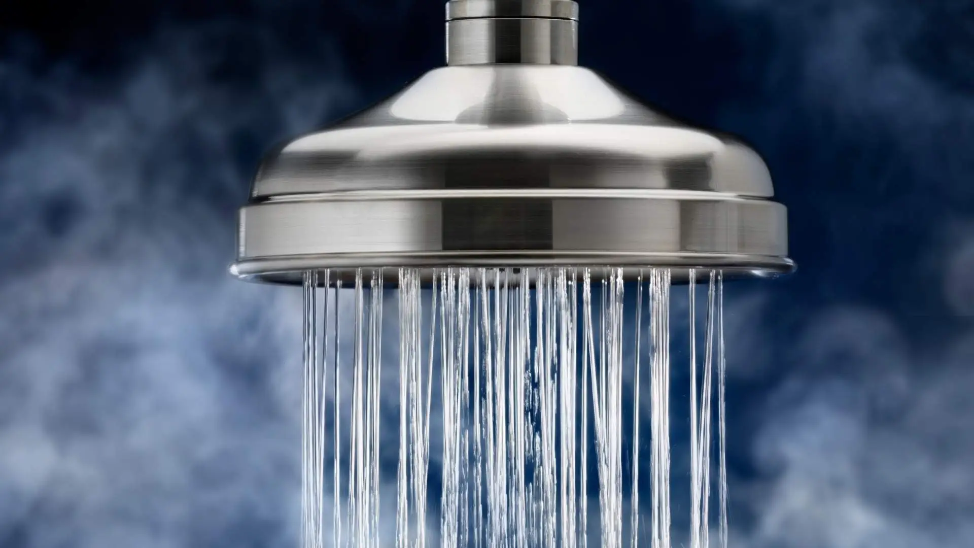 Stainless steel shower head with flowing water.