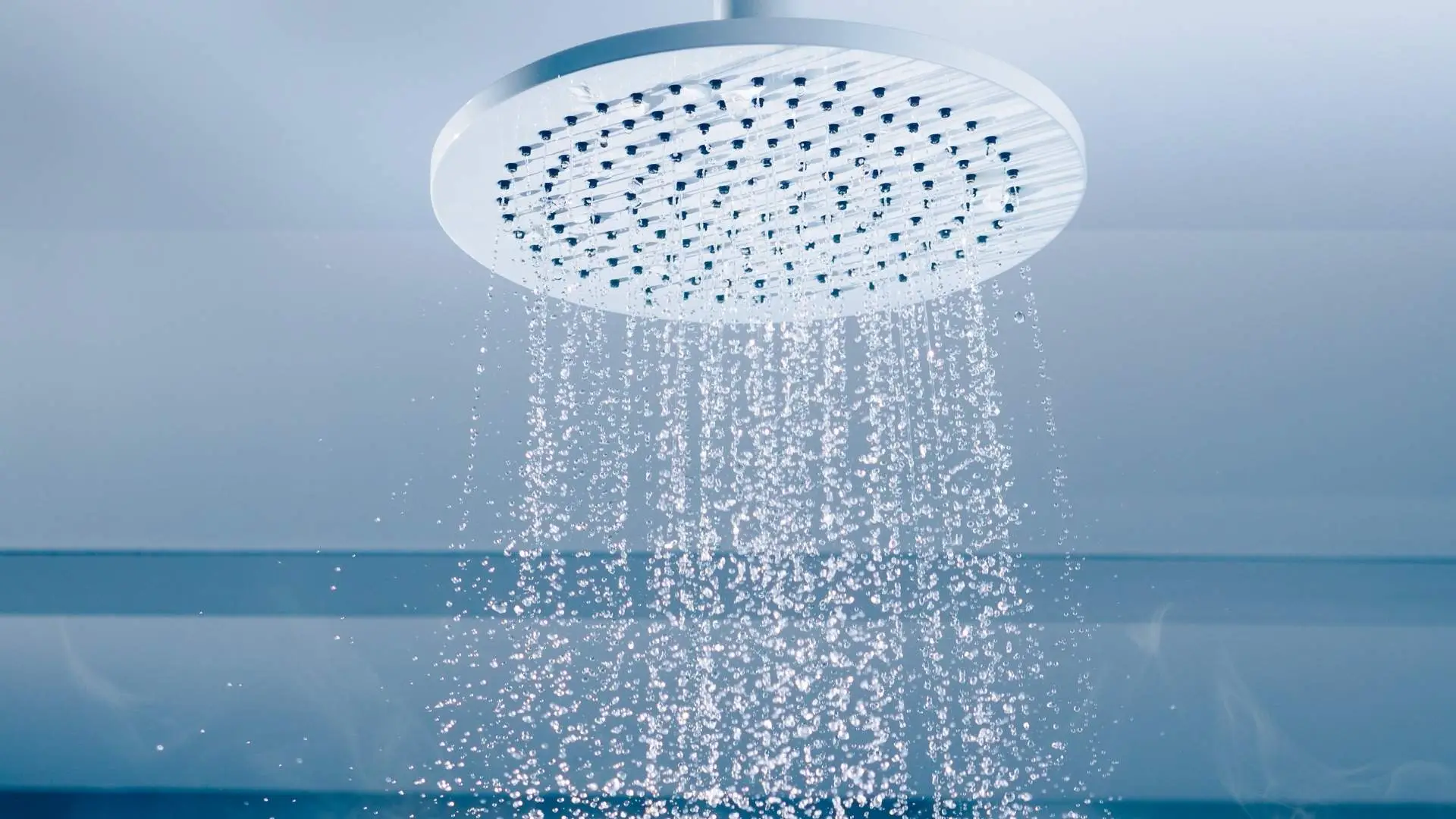 Ceiling showerhead with water spraying downward.
