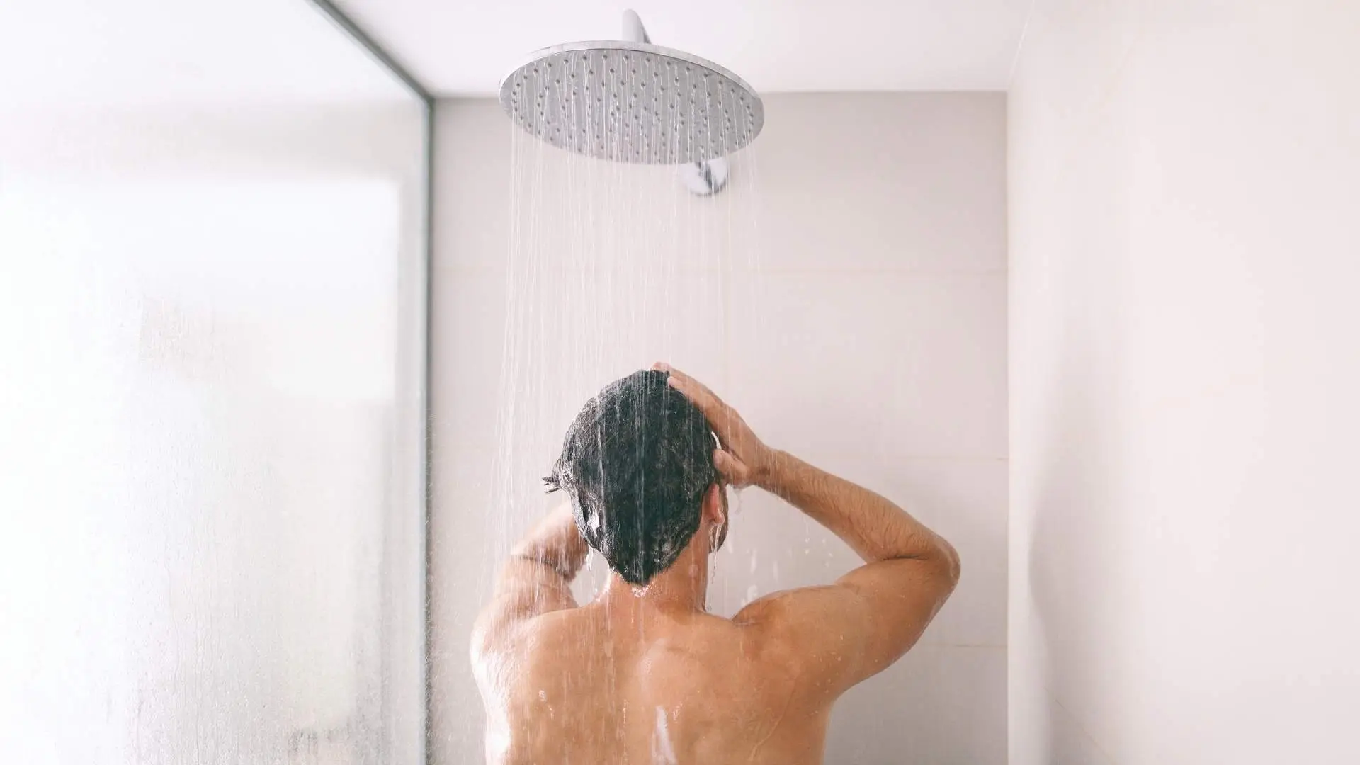 Person showering with overhead showerhead